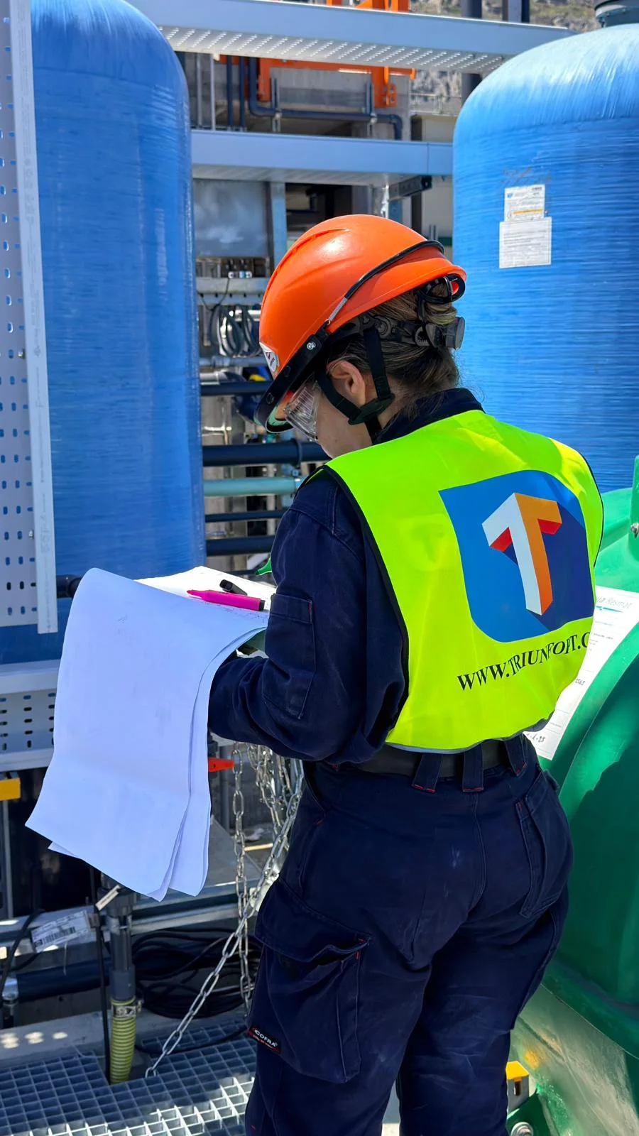 Profesional de Triunfo consultando planos en una instalación